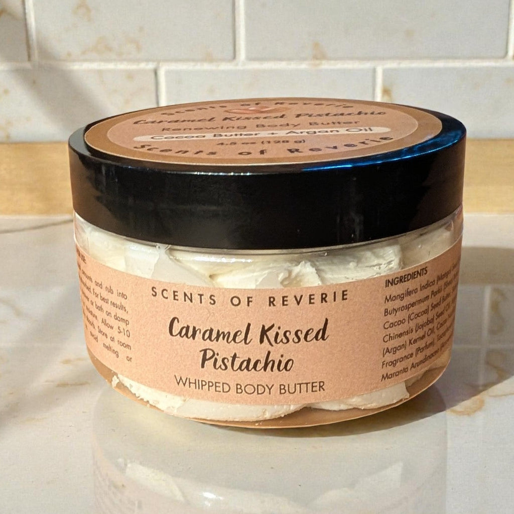 Jar of 'Caramel Kissed Pistachio' whipped body butter on a marble surface with tiled wall background