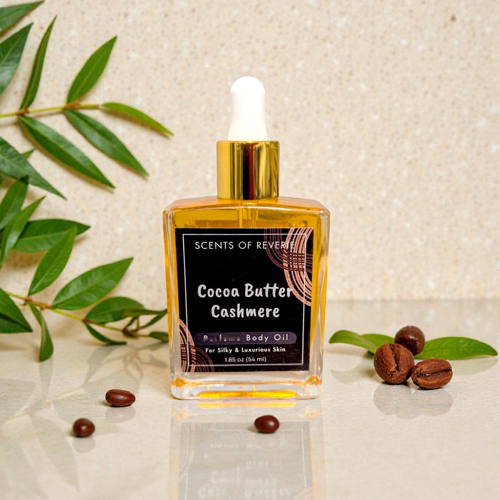 Cocoa Butter Cashmere body oil bottle with leaves and coffee beans on a beige background