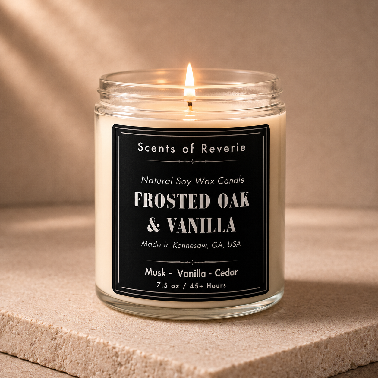 Candle labeled 'Scents of Reverie' with 'Frosted Oak & Vanilla' fragrance on a beige background