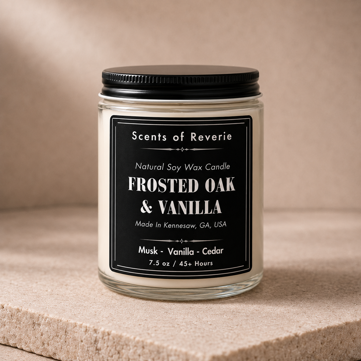Candle jar labeled 'Scents of Reverie' with 'Frosted Oak & Vanilla' on a beige background