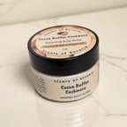 Jar of cocoa butter cashmere whipped body butter on a textured surface
