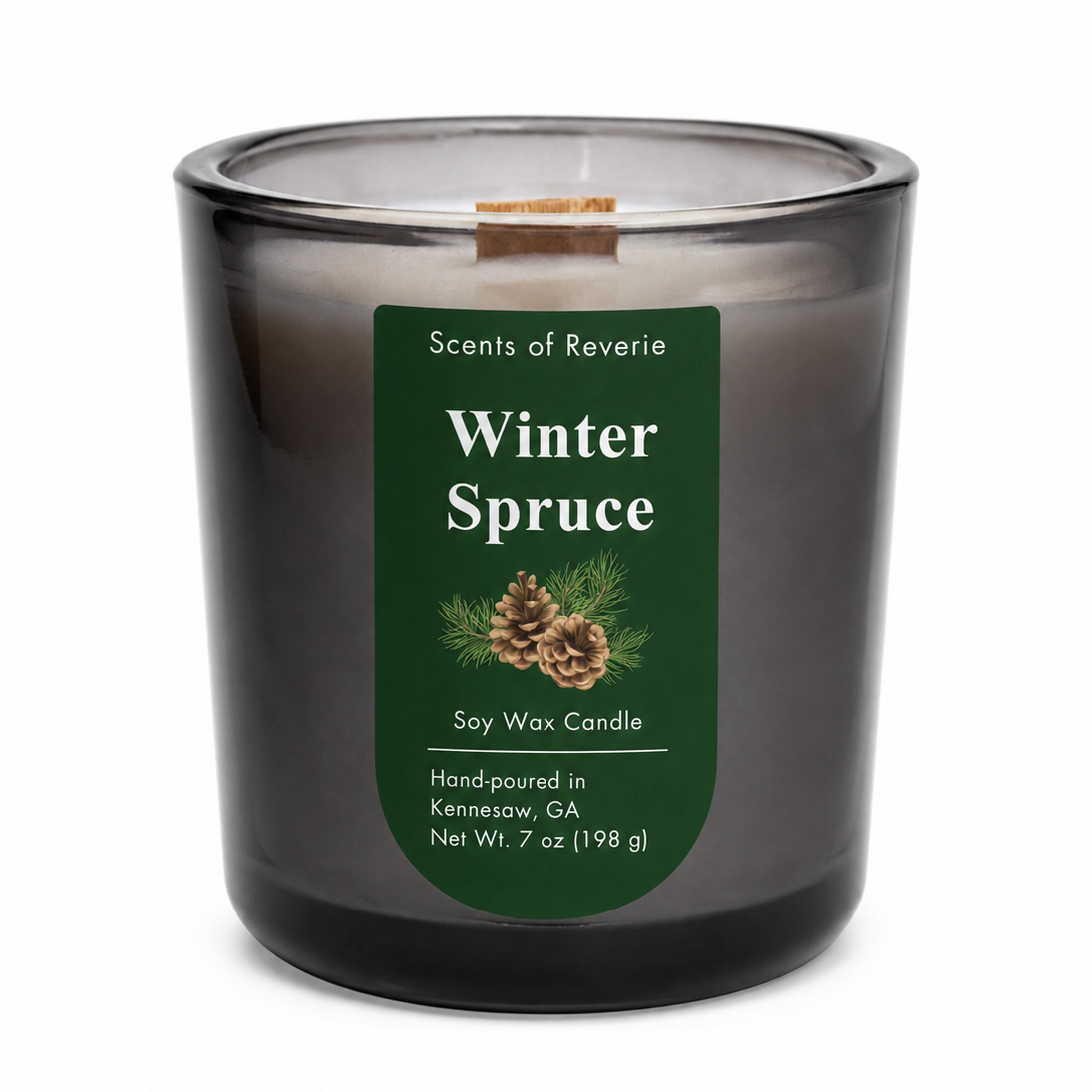 A Scents of Reverie Winter Spruce soy wax candle in a dark gray glass jar with a green label, shown on a white background.